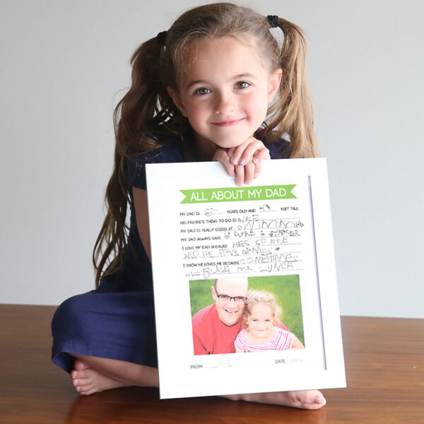 Girl holding father's day questionnaire she has filled out.