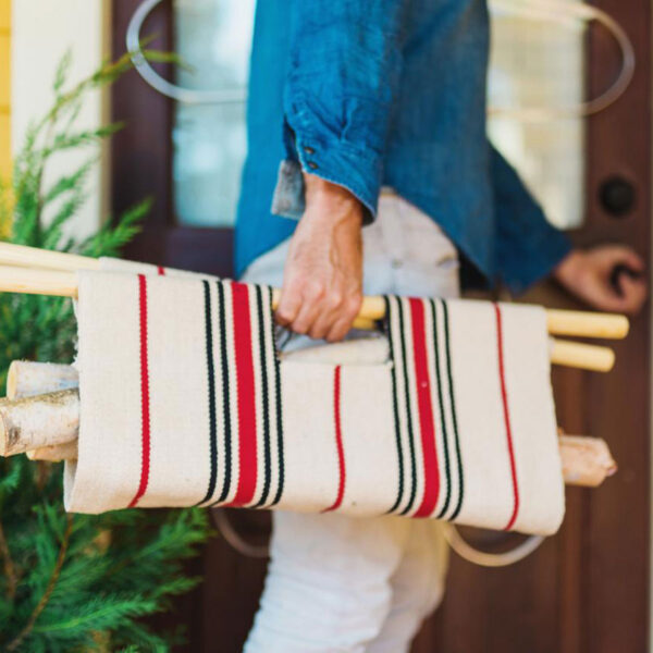 Man carrying firewood in a tote.