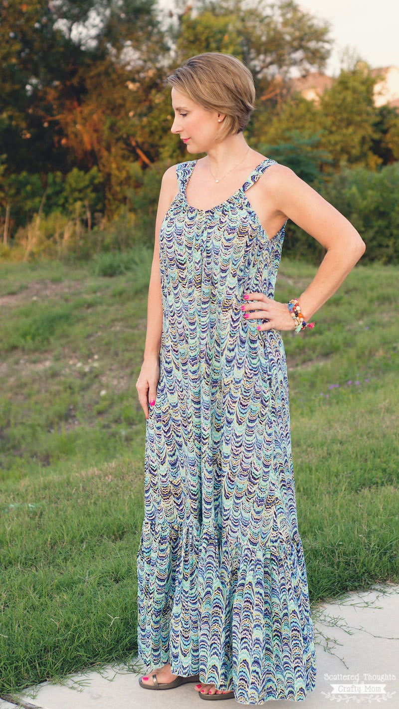A woman wearing a sundress standing in the grass