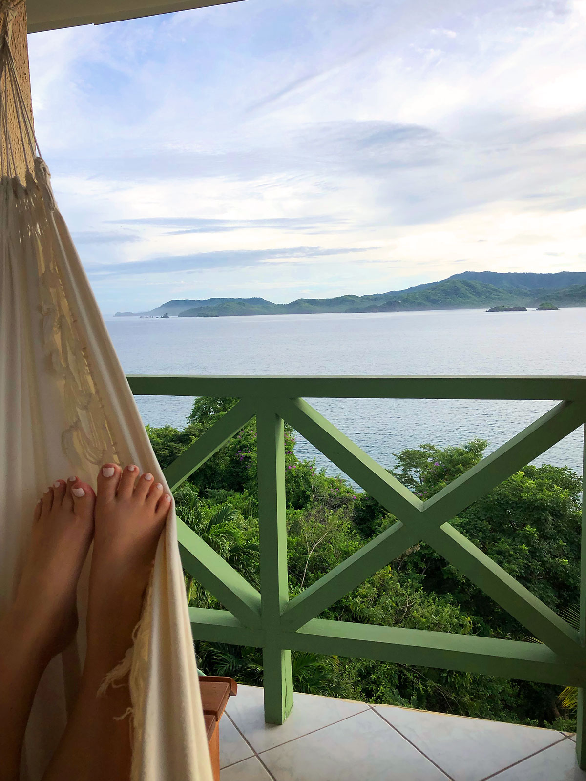 A person in a hammock in front of a body of water