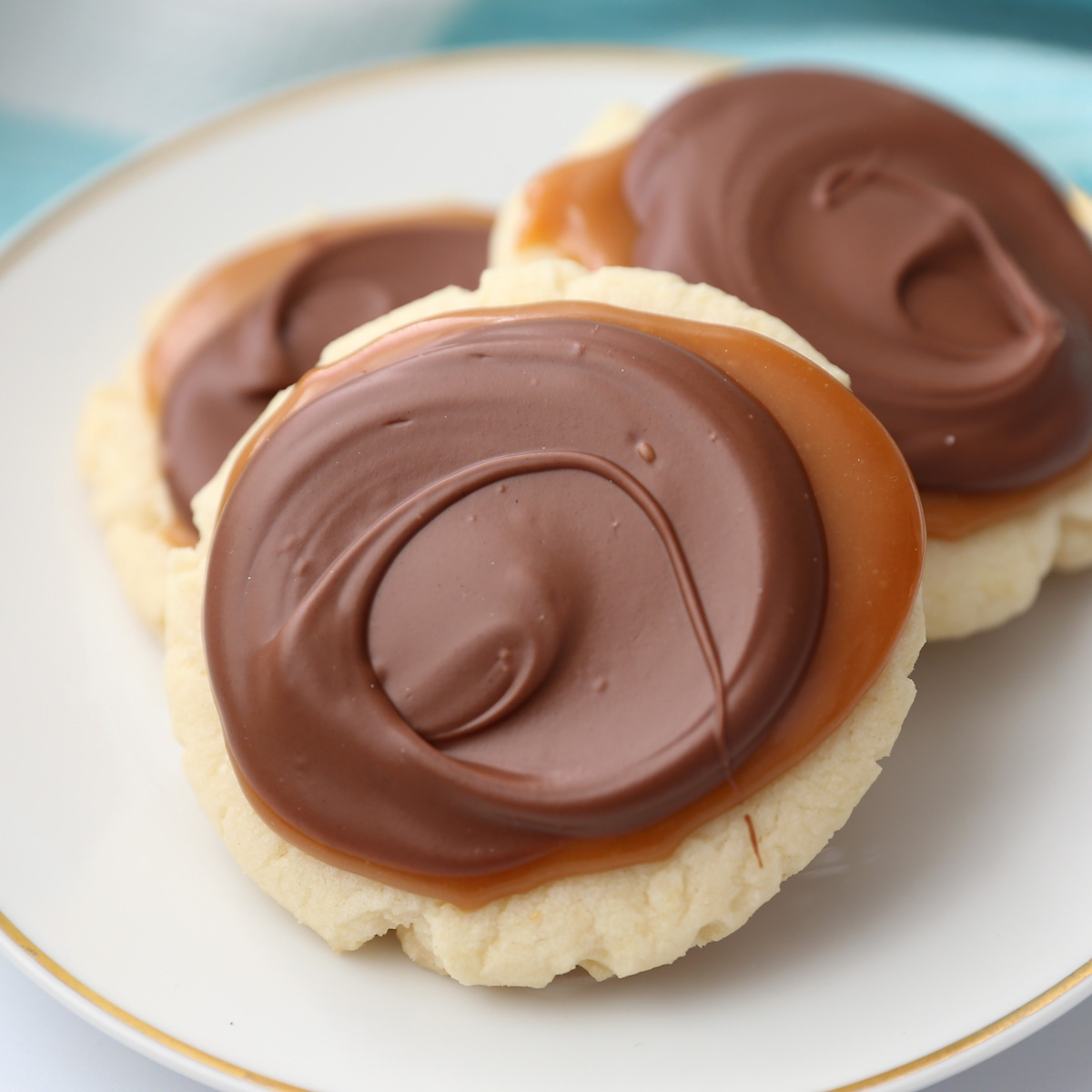 Twix cake mix cookies covered in caramel and chocolate on a plate