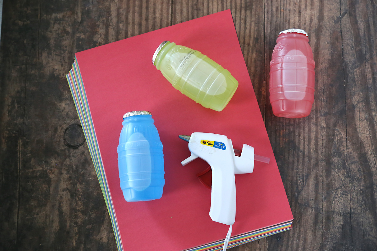 Christmas juice treat supplies: juice, construction paper, hot glue gun