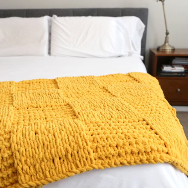 You will not believe how easy it is to make this gorgeous finger knit blanket using loop yarn! Click through for the tutorial.