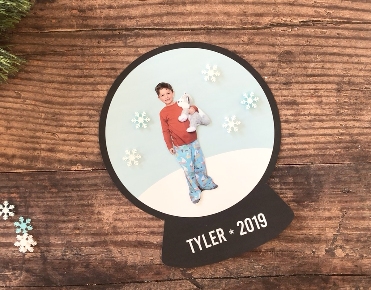 Photo of child cut out and glued onto printed snowglobe template