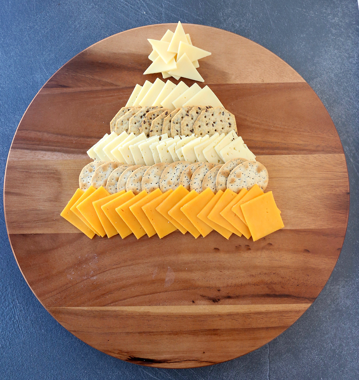 Cheese slices and crackers arranged in triangle Christmas tree shape