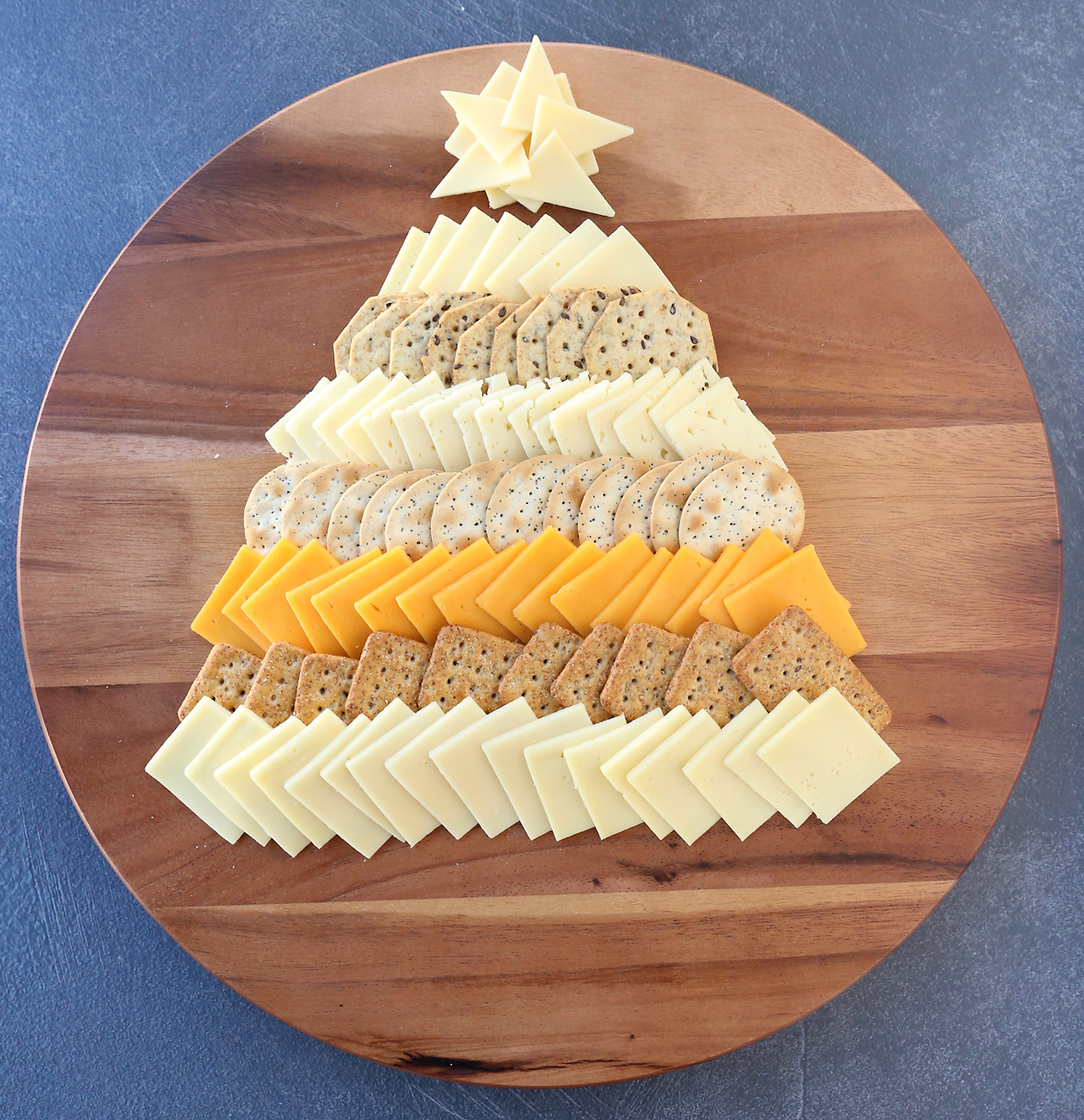 Cheese slices and crackers arranged in triangle Christmas tree shape