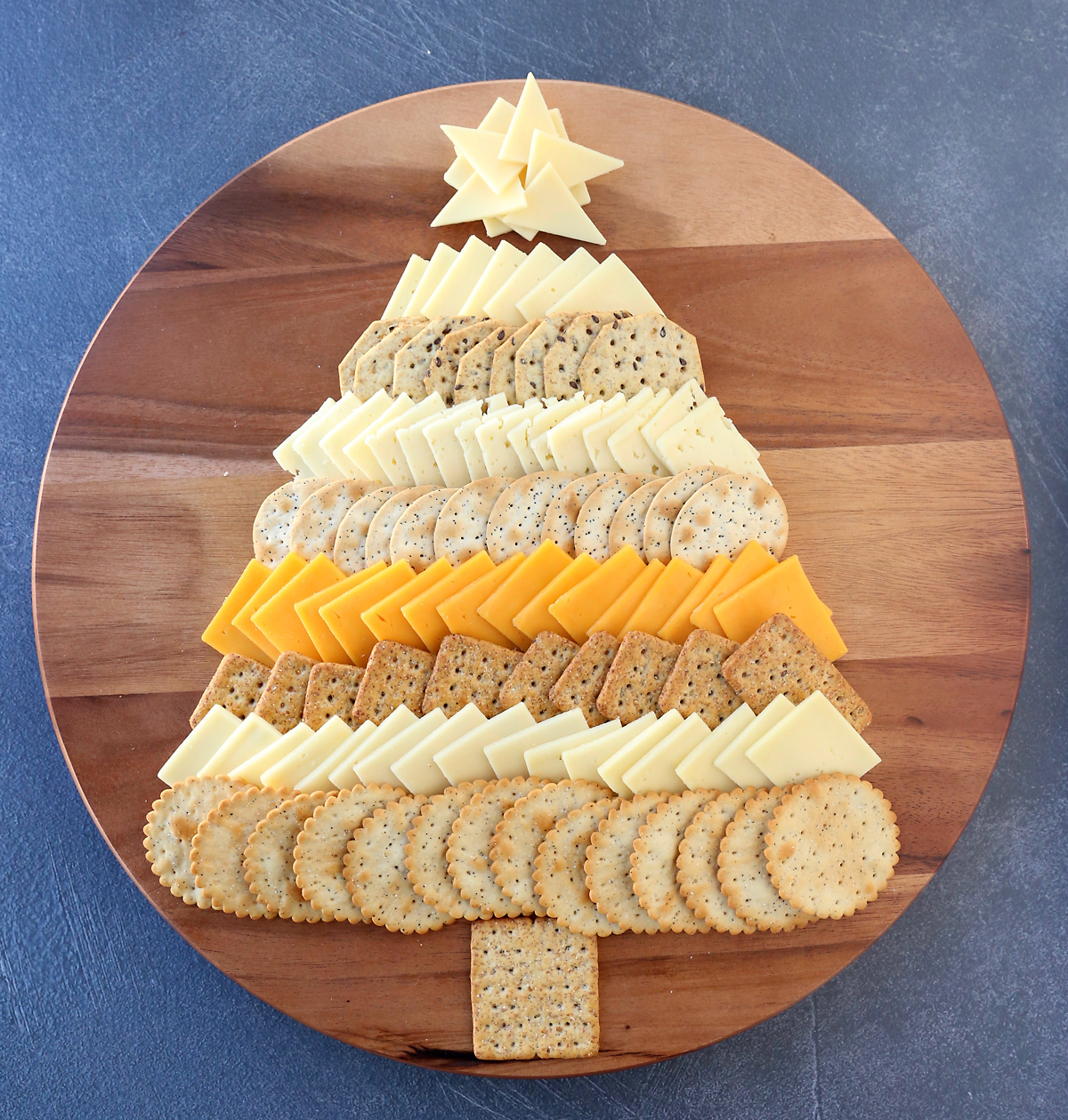 This Christmas Tree Cheese Board is the perfect appetizer for your holiday party! Cheese and crackers arranged like an adorable Christmas tree.