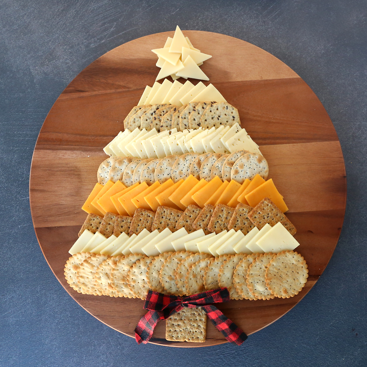 This Christmas Tree Cheese Board is the perfect appetizer for your holiday party! Cheese and crackers arranged like an adorable Christmas tree.