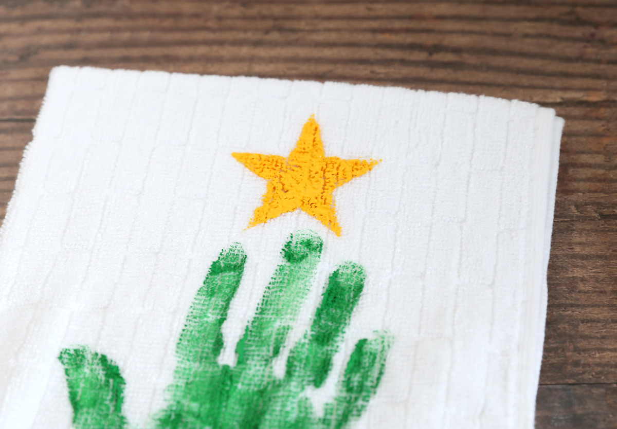 Towel with a green handprint and yellow star above it