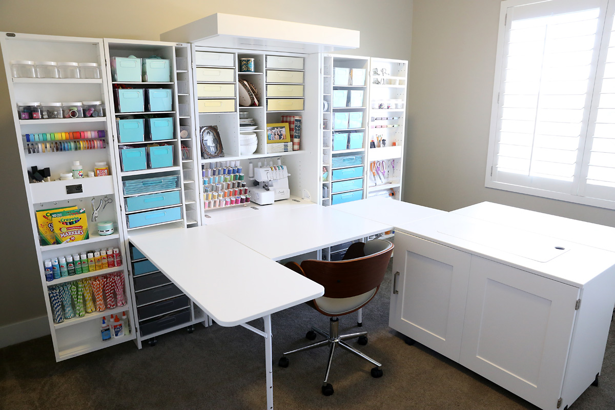 Wall sized craft storage system with multiple shelves and bins to hold supplies as well as a pull out table