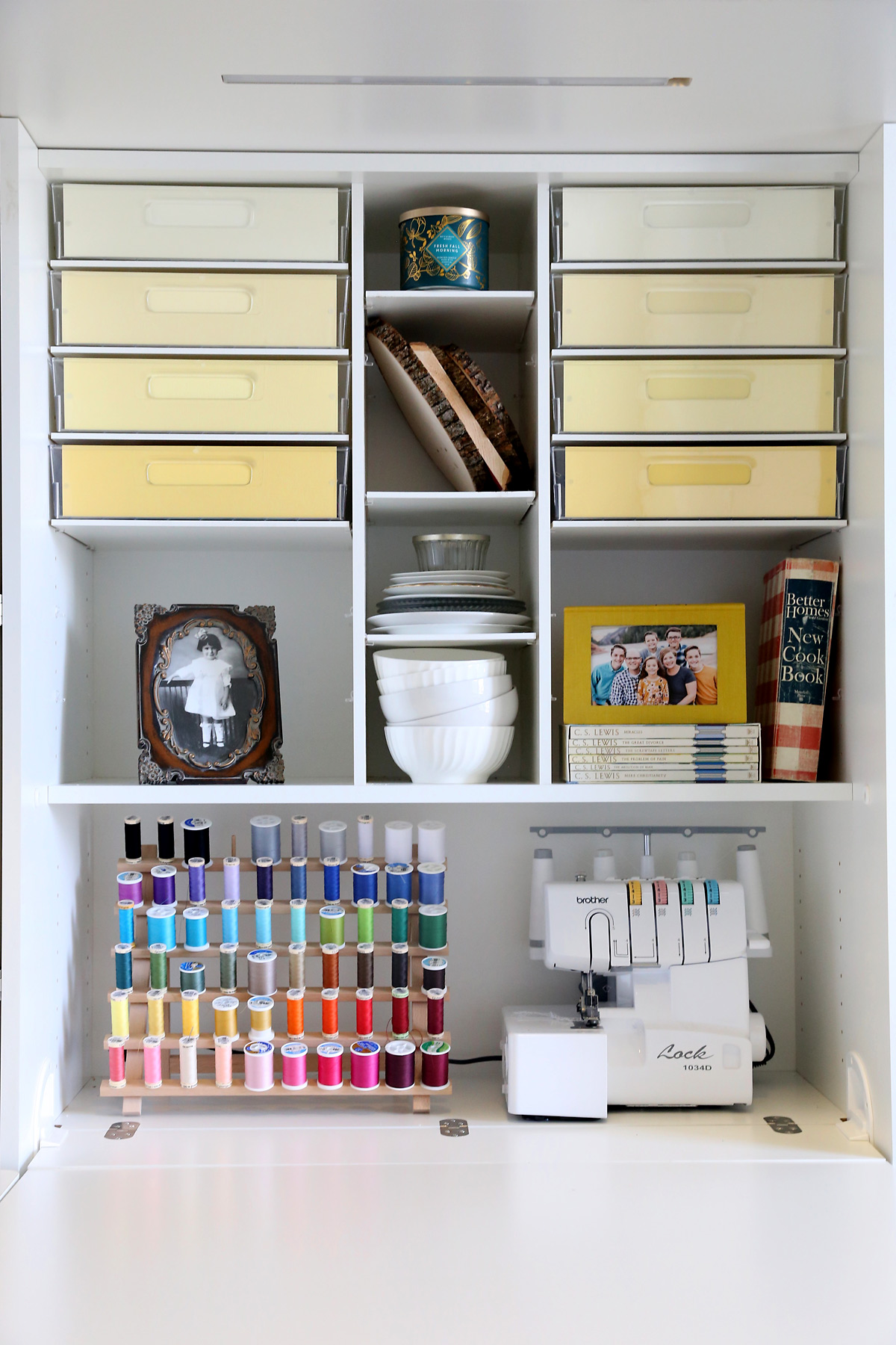 Shelves in a DreamBox with bins, books, sewing machine and thread spool