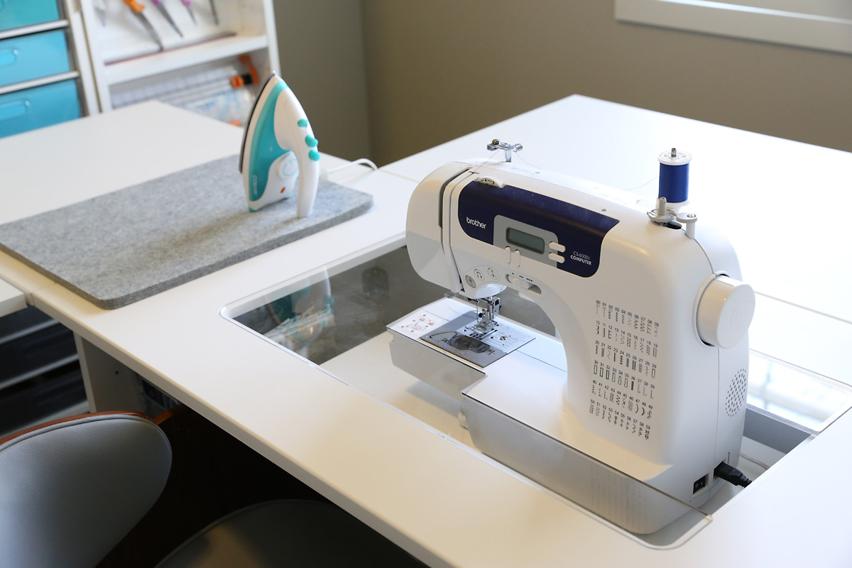 A sewing machine in a custom sewing desk called the Sew Station