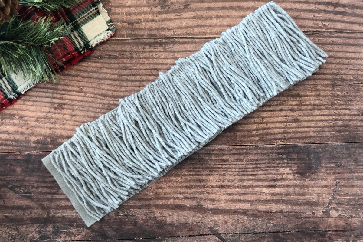 Strip of felt covered with grey yarn and trimmed neatly