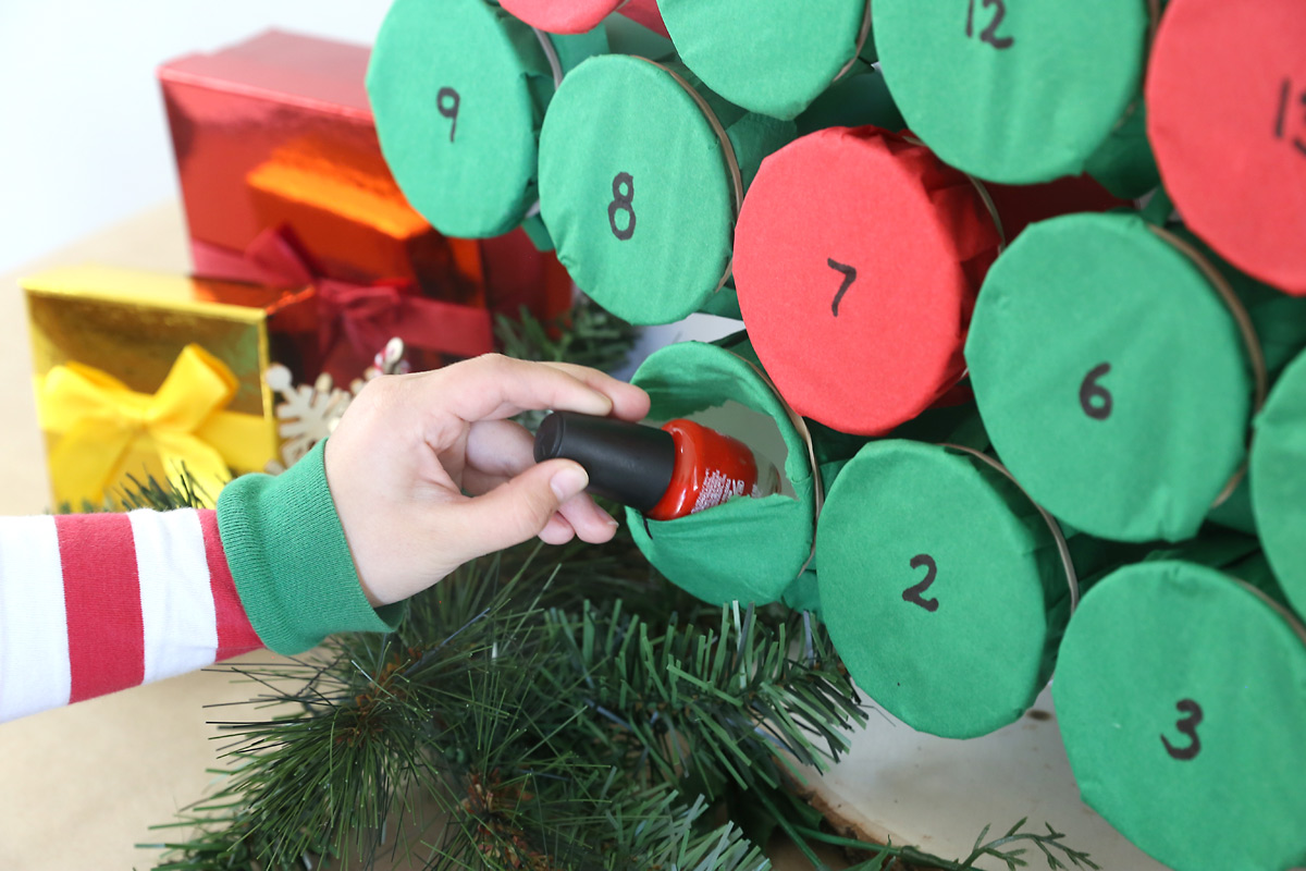 Hand pulling nail polish from punchout advent calendar