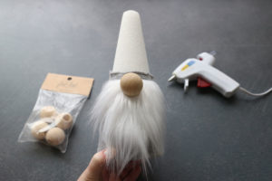 How to make a sock gnome: Glue on beard and wood bead for nose