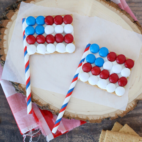 Graham crackers decorated to look like American flags with a paper straw for the flagpole