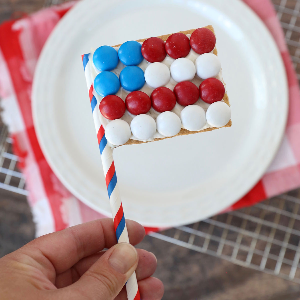 Hand holding a graham cracker decorated to look like an American flag