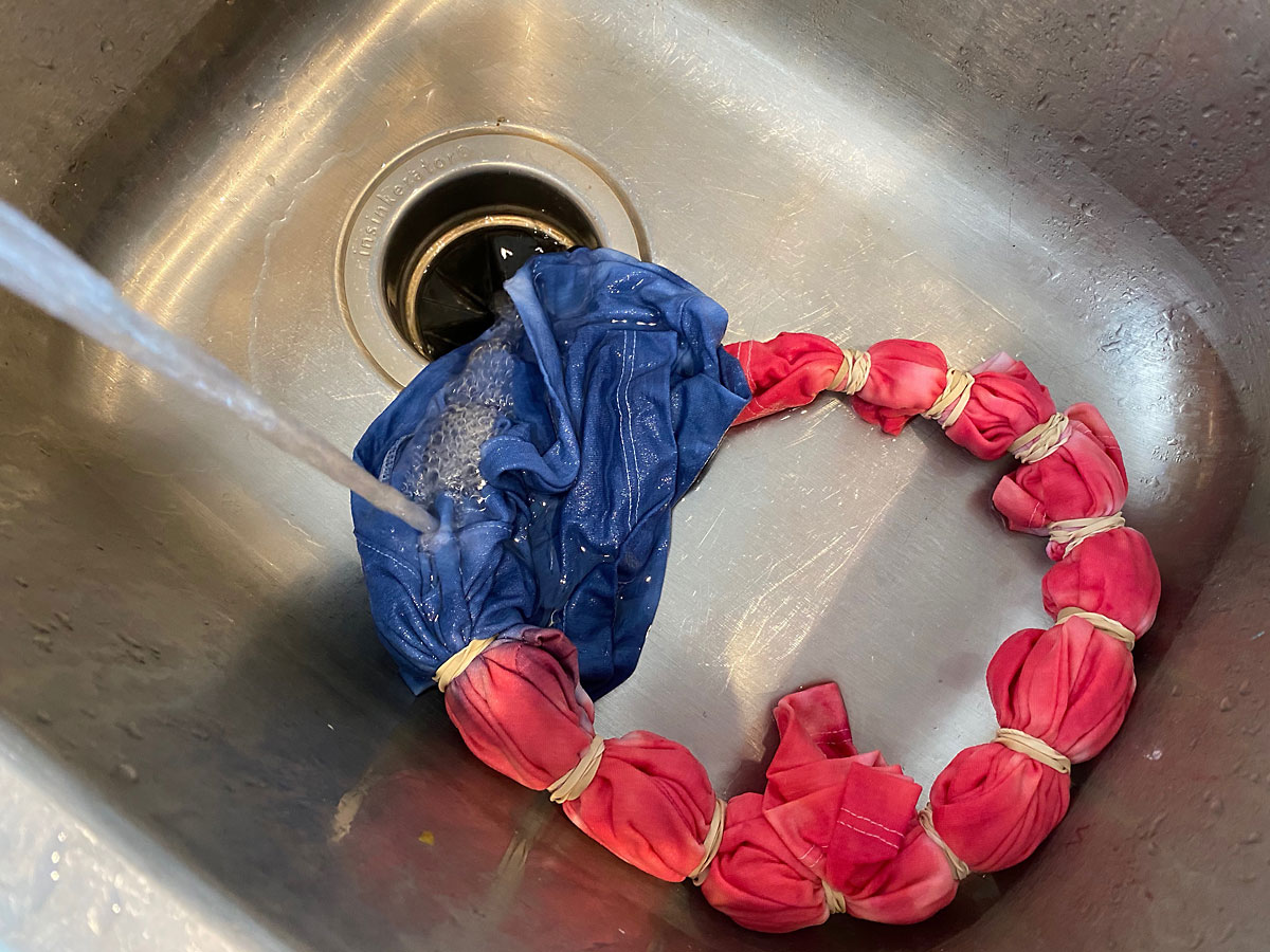 Tie dye shirt getting rinsed in the sink