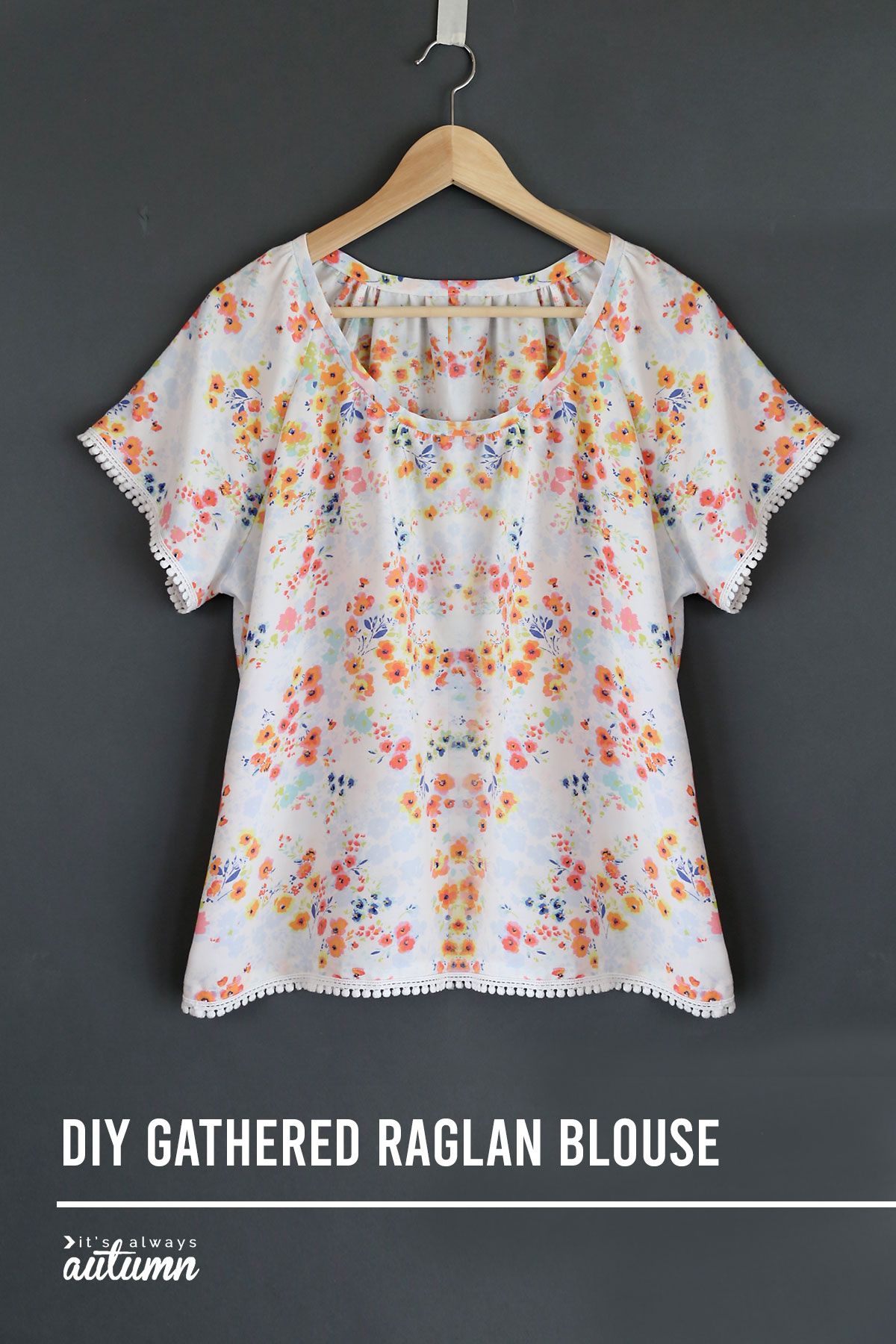 A gathered raglan blouse on a wooden hanger