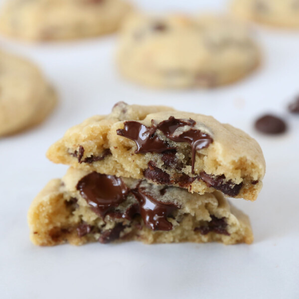 A chocolate chip cookie broken in half to show the soft center and melty chocolate