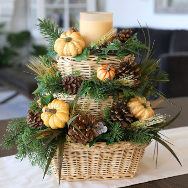 DIY fall centerpiece with baskets, greenery, pinecones, and pumpkins