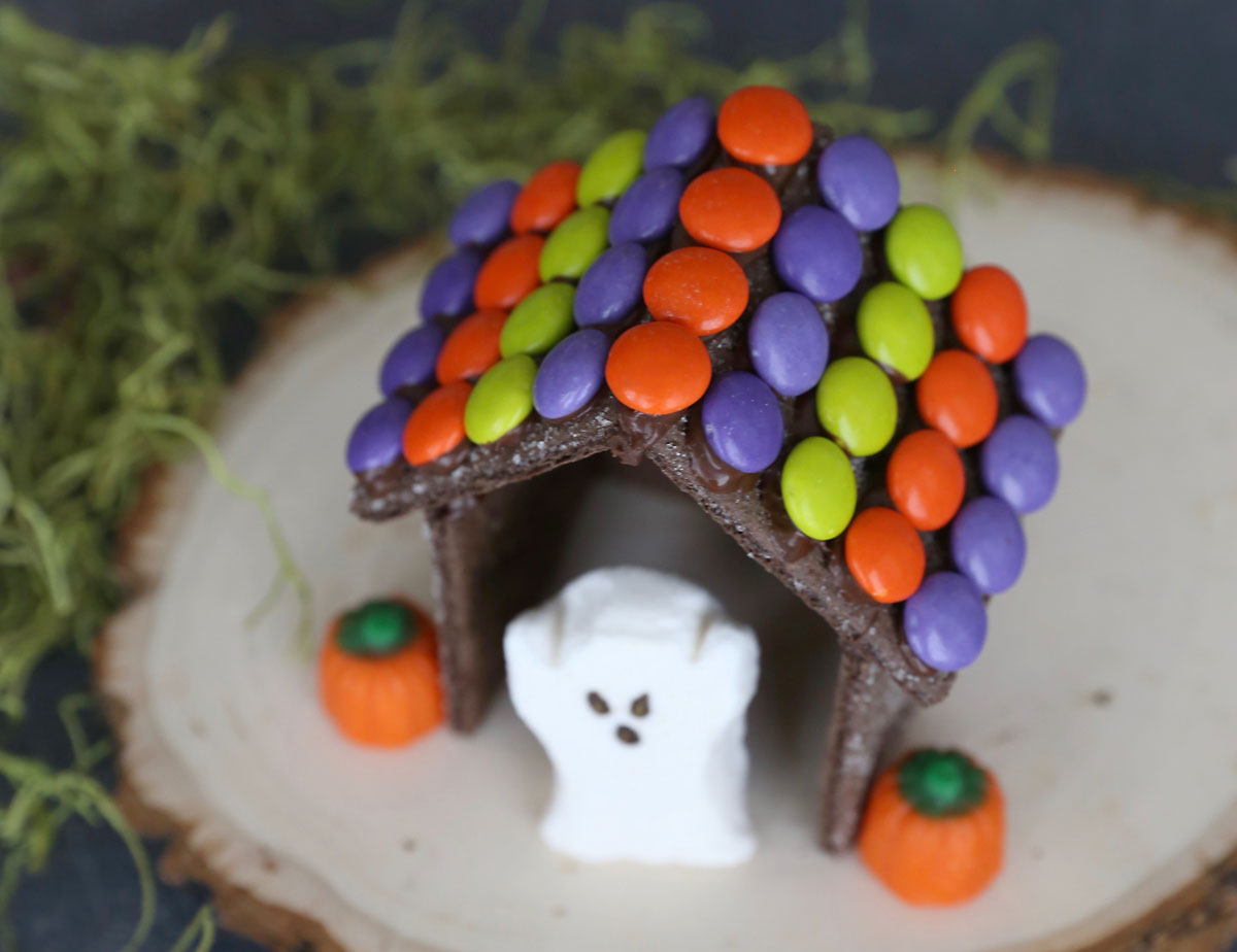 Halloween "gingerbread house" decorated with Halloween M&Ms, Halloween ghost peep, and pumpkin candy