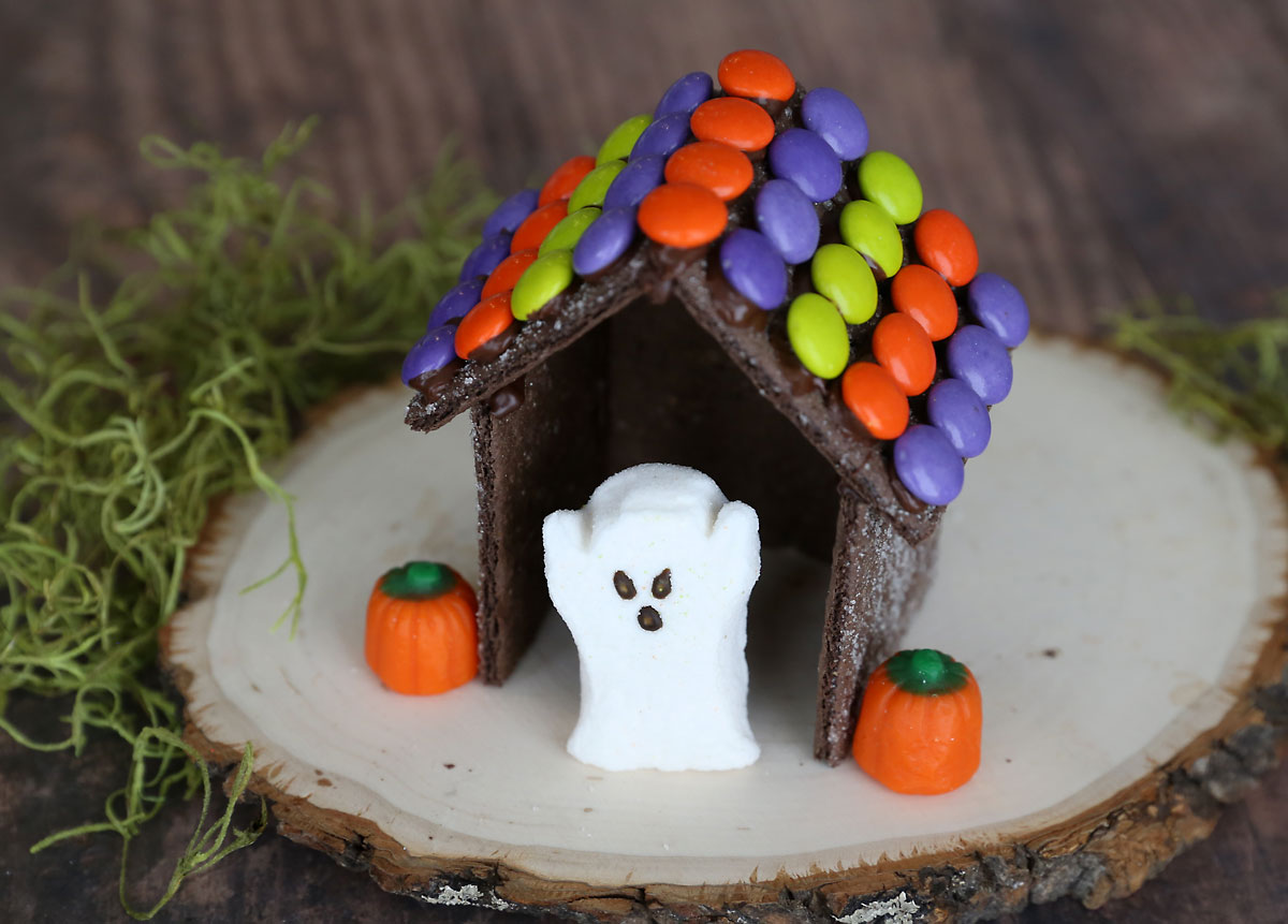 Halloween gingerbread house made from chocolate graham crackers with ghost peeps