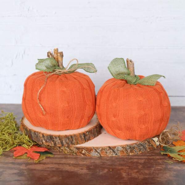 Rolls of toilet paper covered with orange sweater fabric made to look like pumpkins