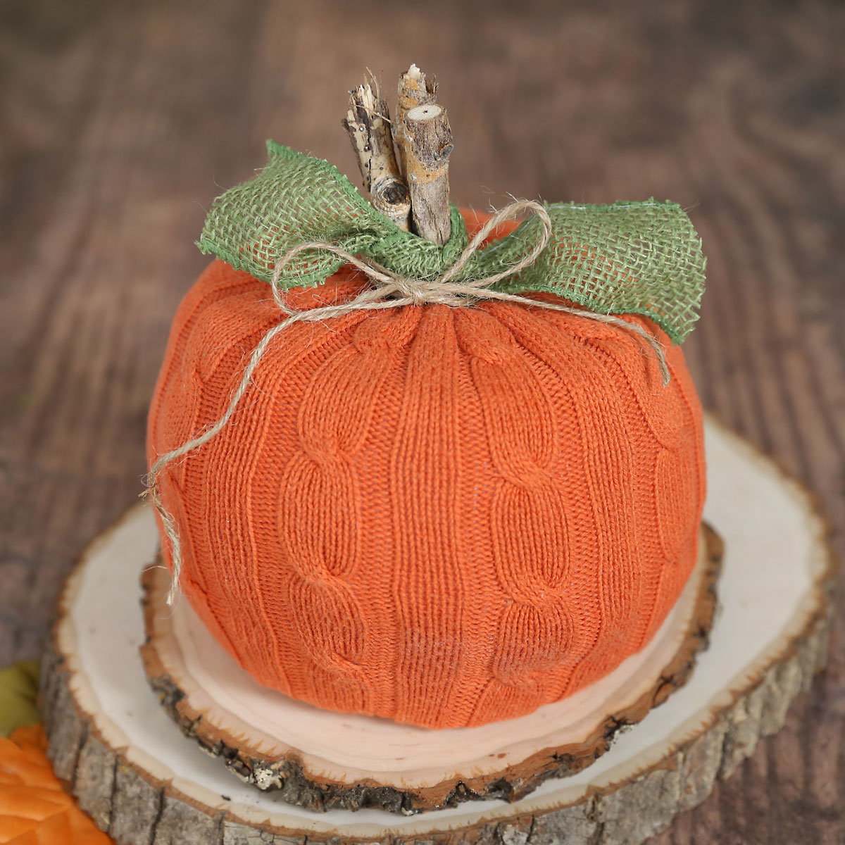 Pumpkin decoration made from a roll of toilet paper covered with orange sweater fabric
