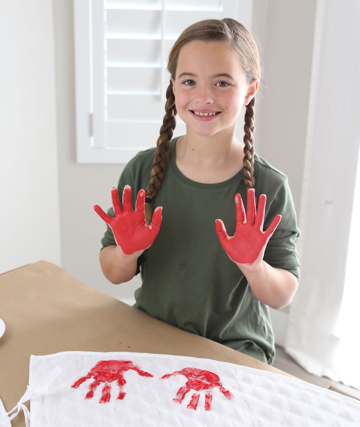 Girl making handprints on a Christmas tree skirt