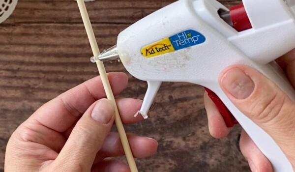 Place hot glue at lowest mark on skewer