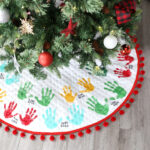 Christmas tree with tree skirt that has kids' handprints on it