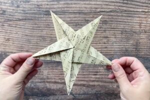 Hands holding paper origami star