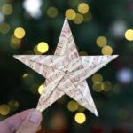 Origami star in front of a Christmas tree
