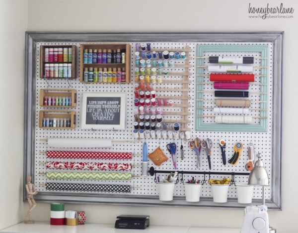 Giant pegboard on a wall with craft supplies hanging from it