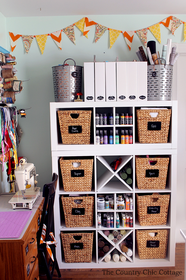 White cube storage unit with wicker baskets and craft supplies