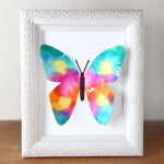 Colorful butterfly made of paper in a white picture frame