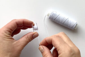 Hand winding elastic thread onto a bobbin