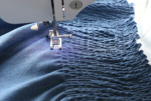 Piece of fabric smocked with elastic thread on a sewing machine