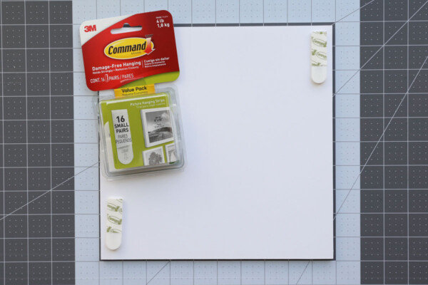 Command small photo strips, two adhered to the back of a photo board