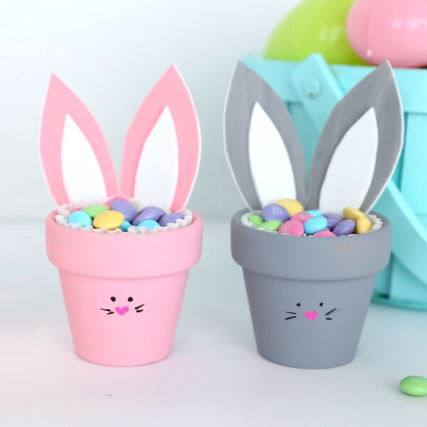 Two flower pot bunnies with Easter candy in front of an Easter basket