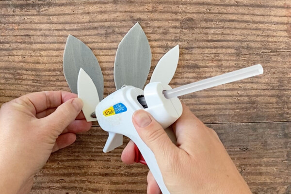 Hand gluing white foam inner ear to grey foam bunny ear