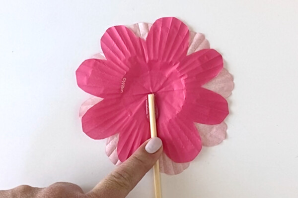 Gluing wood skewer to back of cupcake liner flower