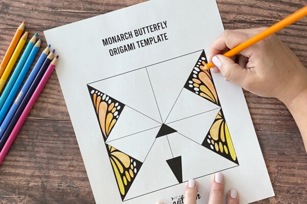 Hand coloring in a Monarch butterfly origami template with coloring pencils