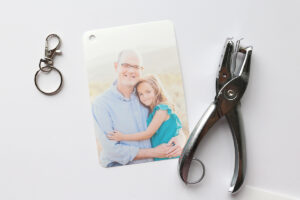 Picture of a girl and her dad printed on shrink film, with keychain attachment and hole punch