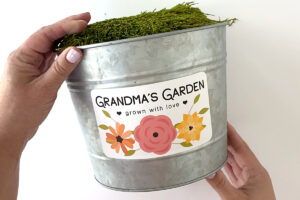 Metal flower pot with label that says Grandma's Garden, grown with love