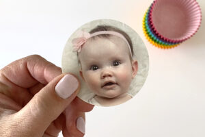 Hand holding photo of a baby cut into a circle