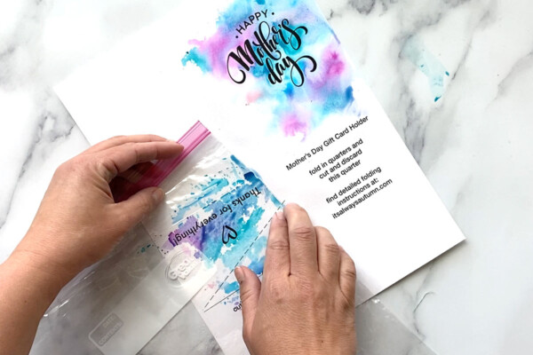 Applying watercolors using a plastic bag on the bottom left quarter of the paper