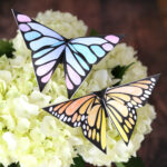 Two origami butterflies on flowers