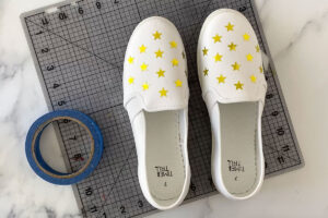Canvas shoes with star stickers on the tops; roll of tape